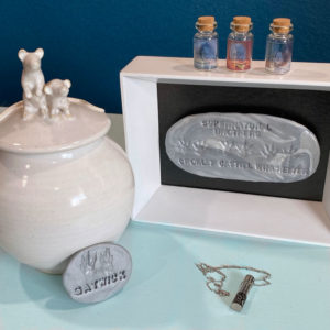 collection of urn, clay paw prints, urn necklace to honor departed pet rats