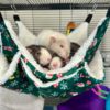 three rats piled atop each other in hammock hanging in cage