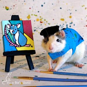 rat dressed as artist posed beside a rat-sized easel with a painting
