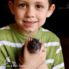 boy holding rat against chest