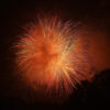 orange fireworks exploding in night sky