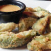 plate of fried avocado slices with dipping sauce