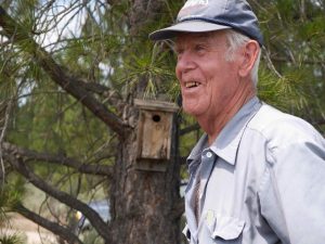 man by birdhouse on tree