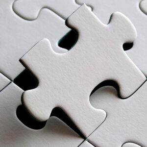 white puzzle piece slotting into place on puzzle