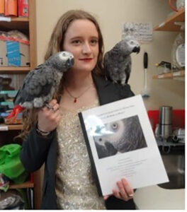 Harvard student with her senior thesis and parrots