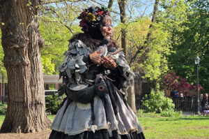 women dressed as pigeon in park talks to children