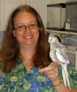 Dr. sue Horton poses with cockatiel on her finger
