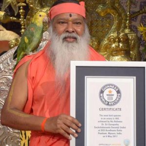 man holds framed sign for Guinness World Record For Aviary With Most Bird Species